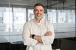 © Stock 4 You - Handsome hispanic senior business man with crossed arms smiling at camera. Indian or latin confident mature good looking middle age leader male businessman on blur office background with copy space.