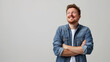 © Fotoksa - Cheerful young man with crossed arms and a contagious smile, radiating positivity and confidence in a stylish casual outfit against a gray background with copy space fot text