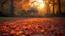 Warm Autumn Sunlight Filters Through Golden Foliage, Illuminating A Carpet Of Red Leaves Leading To A Classic Gazebo In A Tranquil Park Setting