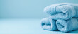 Stack, pile of blue fresh spa, hotel towels on light blue background with copy space for text. Banner design.