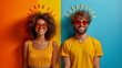 Couple with cool hairstyles and happy smiles standing on colorful background