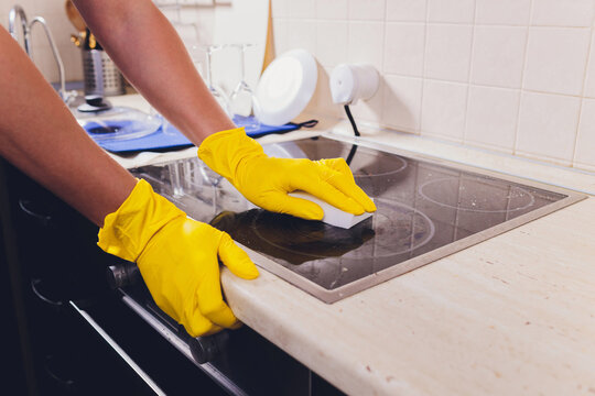 Cleaning kitchen hob with a steam cleaner.