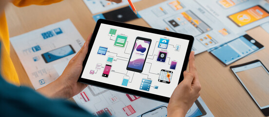 Panorama banner of startup UX developer or company employee design user interface or UI prototype for mobile application or website software with software display on tablet screen in office. Synergic