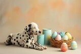 Fototapeta Zwierzęta - A serene Dalmatian puppy lying next to an assortment of paint cans in soft pastel hues and a basket of intricately painted Easter eggs, on a plain beige surface