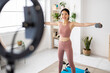 © Xavier Lorenzo - Young asian fitness woman streaming fitness training class using mobile phone. Fitness and content creator people concept.