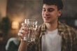 © Miljan Živković - man young caucasian male teenager hold glass of water at home