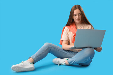 Female programmer working with laptop on blue background