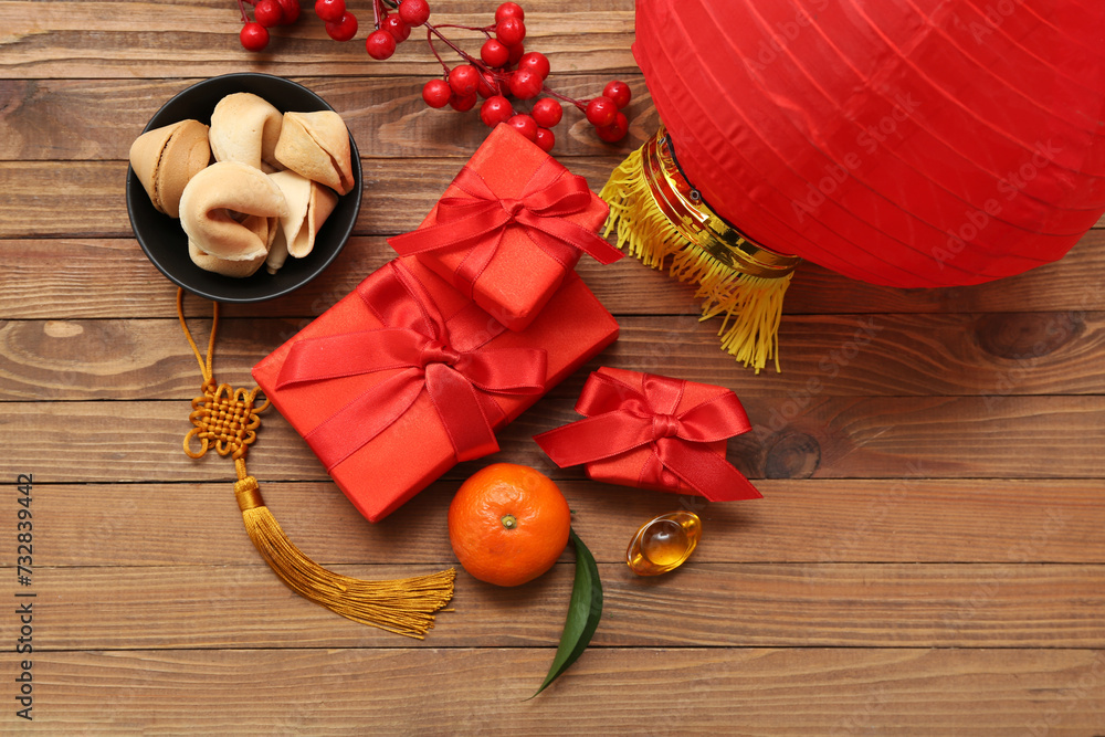Gift boxes with fortune cookies, mandarin and lantern on wooden background. New Year celebration