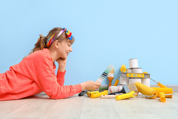 Sticker - Young woman with repair tools lying near blue wall