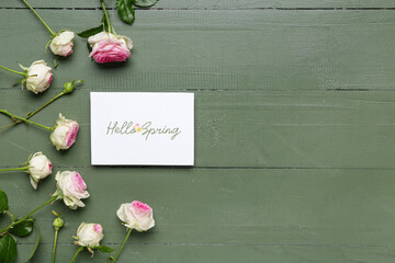 Wall Mural - Greeting card with text HELLO SPRING and beautiful roses on green wooden background