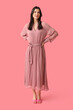 © Pixel-Shot - Beautiful young woman in stylish pink dress on color background