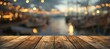 Rustic wooden surface set against blurred backdrop of picturesque harbor capturing essence of coastal escape is perfect for showcasing products with nautical theme