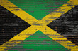 Close-up of old metal wall with national flag of Jamaica . Concept of Jamaica  export-import, storage of goods and national delivery of goods. Flag in grunge style