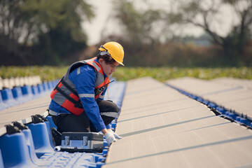 Photovoltaic engineers work on floating photovoltaics. Inspect and repair the solar panel equipment floating on the water.