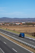 Blue modern delivery small shipment cargo courier van moving fast on motorway road to city urban suburb