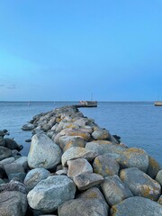 Canvas Print - Vertical of a stone pier on the sea at twilight