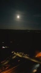 Canvas Print - Vertical night view of beautiful full moon lighting the sky over the city