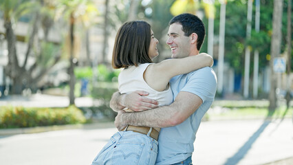 Beautiful couple smiling confident hugging each other at street