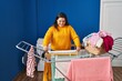 © Krakenimages.com - Young beautiful plus size woman smiling confident hanging clothes on clothesline at laundry room