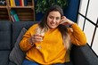 © Krakenimages.com - Young beautiful plus size woman drinking wine sitting on sofa at home