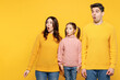 © ViDi Studio - Young shocked scared sad parents mom dad with child kid girl 7-8 years old wear pink knitted sweater casual clothes look aside on area mock up isolated on plain yellow background. Family day concept.