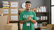 © Krakenimages.com - Confident young latin man clapping hands with a smiling face, exuding joy as an involved volunteer at the heart of community charity center