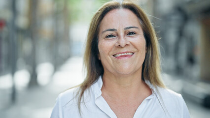 Sticker - Middle age hispanic woman smiling confident standing at street