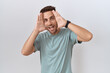 © Krakenimages.com - Hispanic man with beard standing over white background smiling cheerful playing peek a boo with hands showing face. surprised and exited