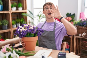 Poster - Caucasian blond man working at florist shop shouting and screaming loud to side with hand on mouth. communication concept.