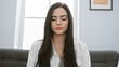 © Krakenimages.com - A serene young hispanic woman in a white blouse meditates indoors, providing a peaceful, attractive portrait scene.