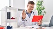 © Krakenimages.com - Young man doctor using touchpad having video call at clinic