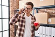 © Krakenimages.com - Young man ecommerce business worker talking on smartphone drinking coffee at office