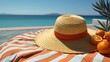 A top view of a colorful beach towel and sun hat against a serene sky blue background, signaling the start of a relaxing day by the shore