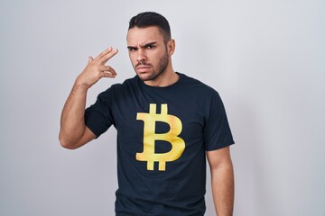 Canvas Print - Young hispanic man wearing bitcoin t shirt shooting and killing oneself pointing hand and fingers to head like gun, suicide gesture.