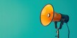 © Ярослава Малашкевич - A director's megaphone on a bright turquoise background, suitable for a film director's masterclass advertisement, a theater production call announcement, or an event organizing service promotion.