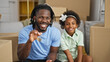 © Krakenimages.com - African american father and daughter holding new house keys sitting on sofa speaking at new home