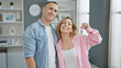 © Krakenimages.com - Man and woman couple standing together holding keys at home