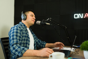 Handsome latin man in the soundproof studio recording a podcast