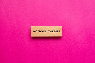 Wall Mural - Motivate yourself words written on wooden block with pink background. Conceptual symbol. Copy space.