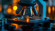 © wing - A microscope with a dark background and orange lights shining on it.