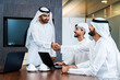 Group of corporate arab businessmen meeting in the office - Business people wearing emirati clothing  working in the office