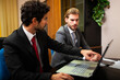 © Minerva Studio - Businessmen discussing work on laptop at office