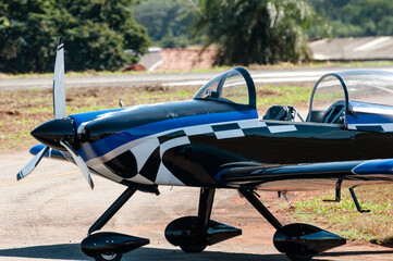 Single-engine aerobatic display plane being parked at a flying club