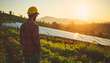Worker on a solar farm. Photovoltaic system. Solar power generation. Solar plant. Sustainable electricity from solar energy. Energy transition. Sustainable energy generation. Clean energy. At Sunset.