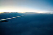 Vista da asa de um avião comercial passando diretamente entre a tempestade e a nuvem Cumulonimbus. Tons fortes de roxo, azul e laranja.