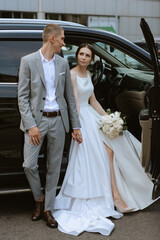 Wall Mural - bride and groom with a black car