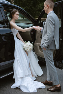bride and groom with a black car