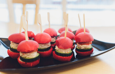 Wall Mural - Different canapes with smoked salmon, cucumber cherry tomatoes and mozzarella served on a table.