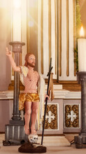 A Wooden Figure Of Jesus By An Unknown Author In A Church Next To Burning Candles
