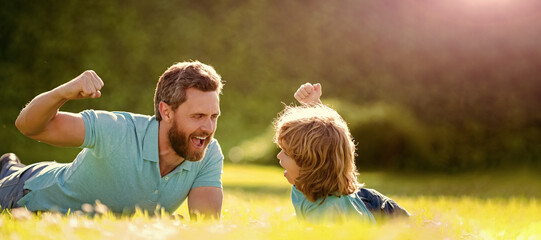 Wall Mural - Banner of father and son in summer park outdoor. parent relax with little child boy on grass. glad dad with kid on summer day.